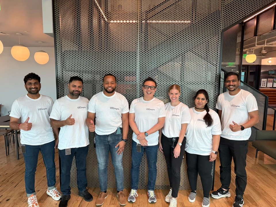 Dave and six teammates standing together in white EIQdigital shirts.