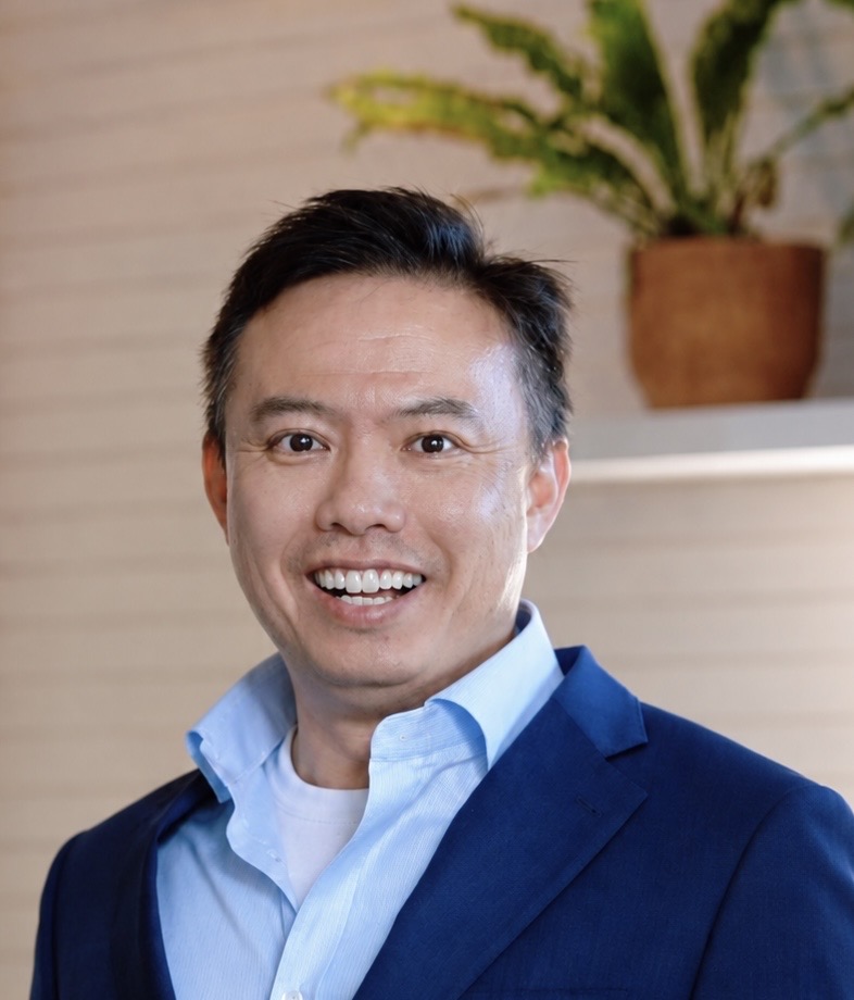 Dave smiling in a navy blazer and light blue shirt.